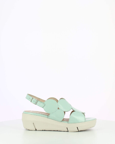 Mint Patent sling back wedge sandal with cutouts on a white base.