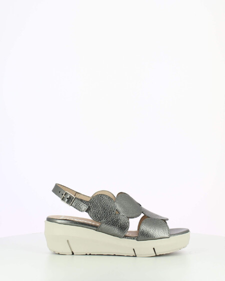 Metallic sling back wedge sandal with cutouts on a white base.