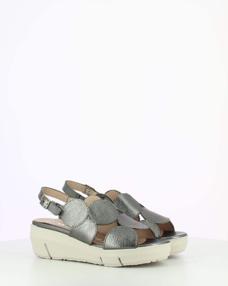 Metallic sling back wedge sandal with cutouts on a white base.